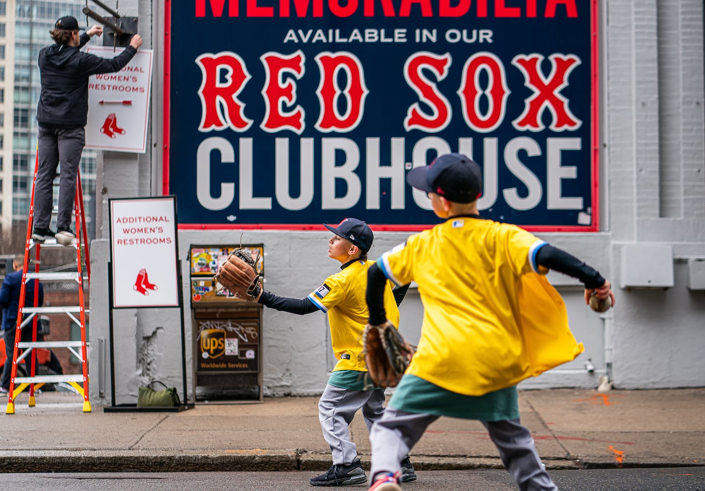 Twins Tyler and Taylor Gonick, 11, of New Jersey play catch with their father before Opening Day at Fenway Park.