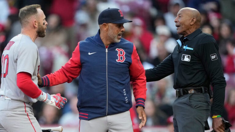 Boston Red Sox manager Alex Cora, center, and Boston Red Sox's Trevor Story, left, dispute a call with home plate umpire CB Bucknor before Cora is ejected during the eighth inning of a baseball game against the Cincinnati Reds in Cincinnati, Saturday, March 28, 2026.