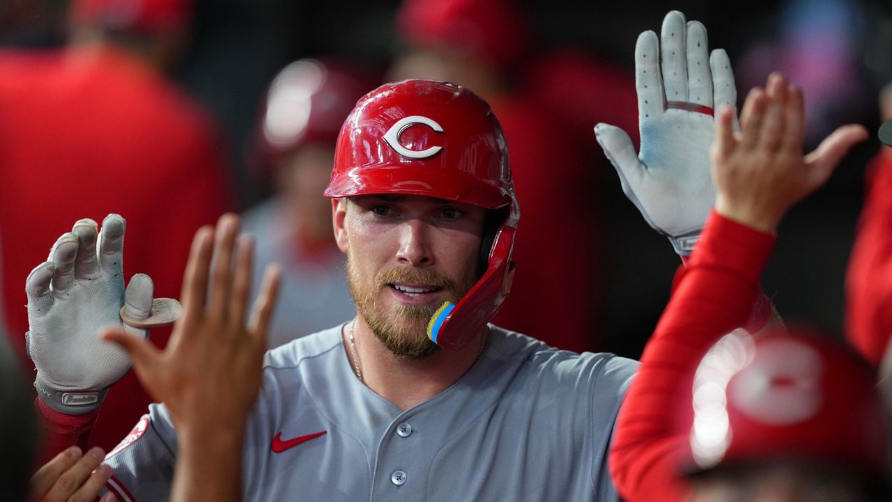 Cincinnati Reds' Tyler Stephenson is greeted in the dugout after hitting a two-run home run off Texas Rangers pitcher Chris Martin during the ninth inning of the Rangers' home-opener baseball game Friday, April 3, 2026, in Arlington, Texas. (AP Photo/Julio Cortez)