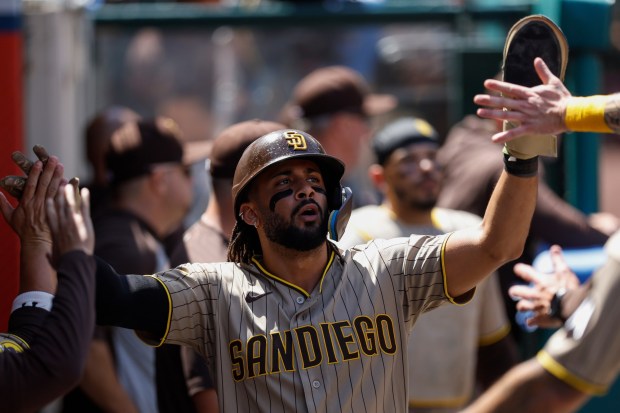 The Padres' Fernando Tatis Jr. is greeted by teammates after scoring during the fourth inning of a baseball game against the Los Angeles Angels, Sunday, April 19, 2026, in Anaheim, Calif. (AP Photo/Caroline Brehman)