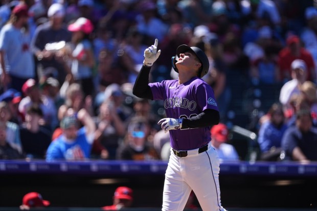 Colorado Rockies' Mickey Moniak gestures as he circles the bases after hitting a solo home run off Philadelphia Phillies starting pitcher Taijuan Walker (99) in the fifth inning of a baseball game Sunday, April 5, 2026, in Denver. (AP Photo/David Zalubowski)