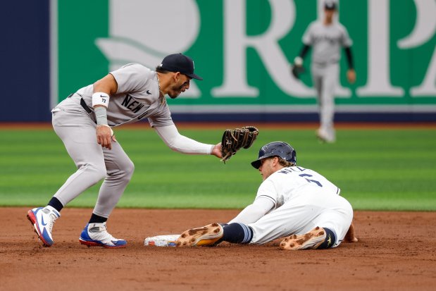 The Rays' Taylor Walls, right, successfully steals second base as New York Yankees shortstop Jose Caballero attempts to tag him out last Sunday, April 12, 2026, at Tropicana Field. (Jefferee Woo/Tampa Bay Times)