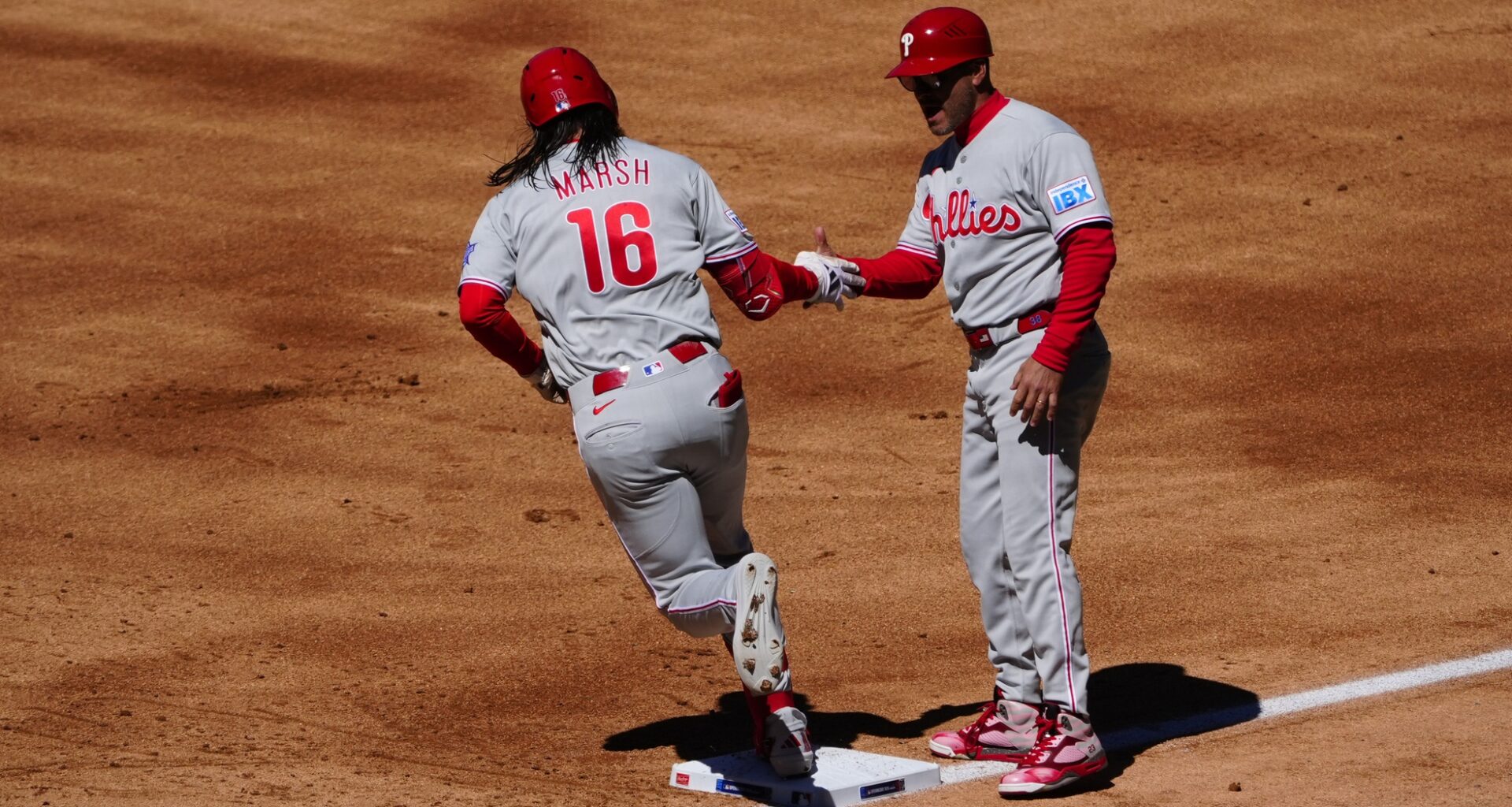 Apr 3, 2026; Denver, Colorado, USA; Philadelphia Phillies center fielder Brandon Marsh (16) celebrates his three run home run with first base coach Paco Figueroa (38) in the first inning against the Philadelphia Phillies at Coors Field.
