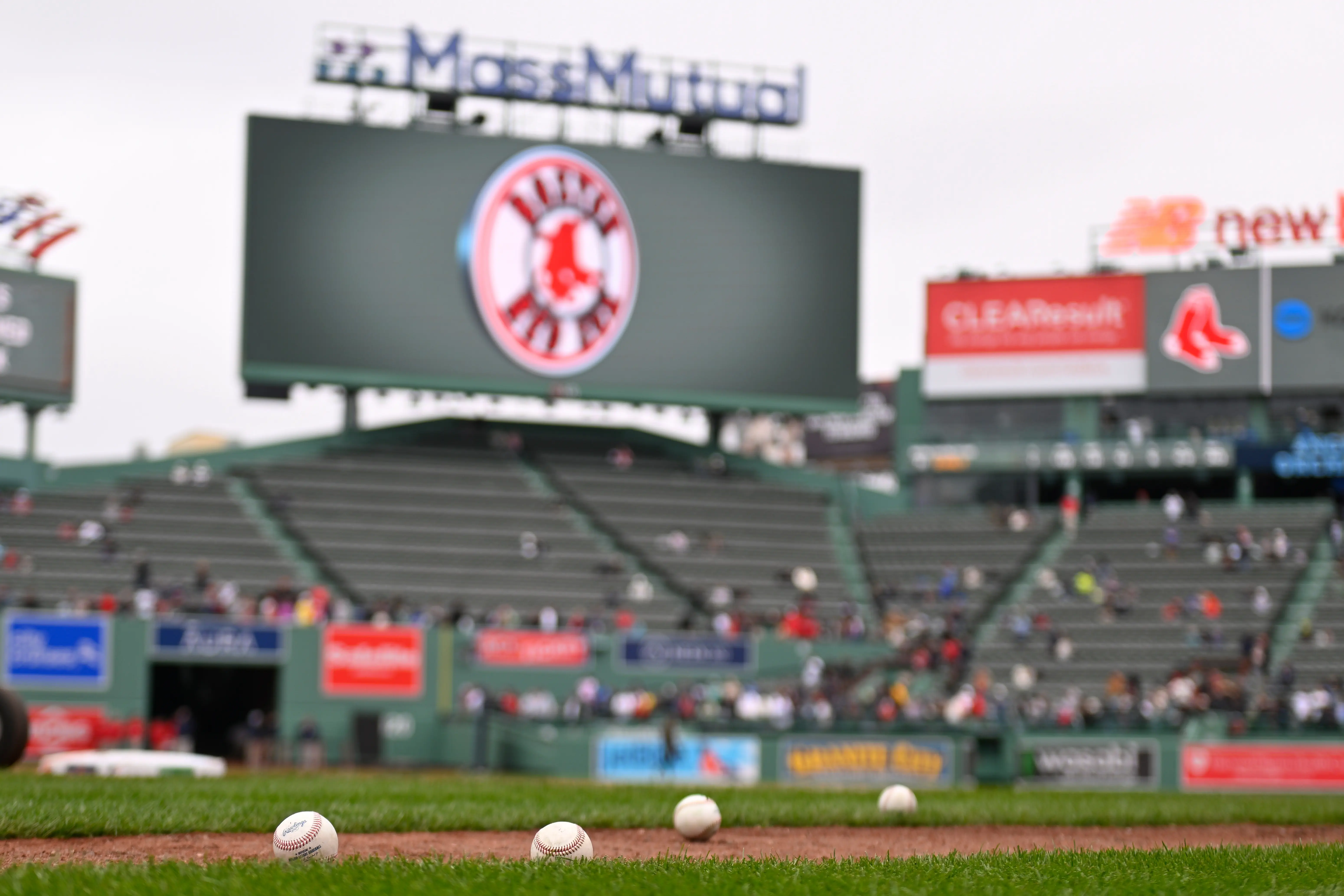 Baseballs sit on the infield during batting practice before a game at Fenway Park.