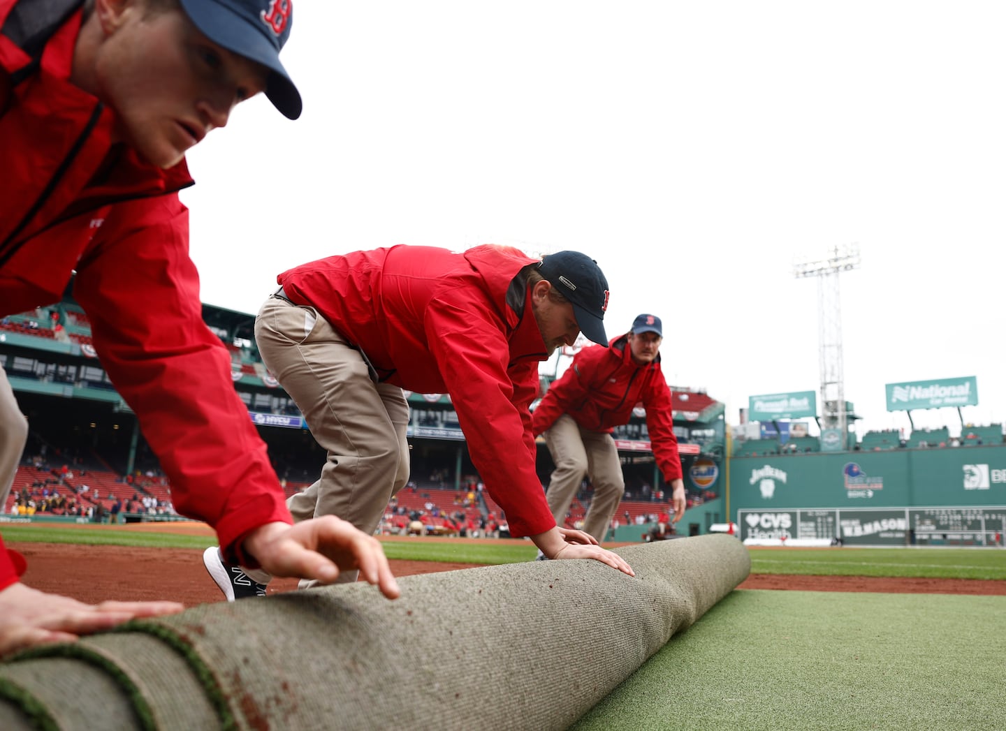 The Fenway Park field crew prepare the field before the home opener.