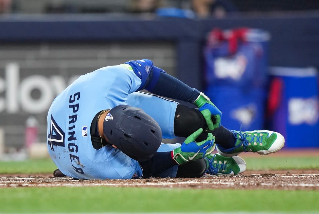 Toronto Blue Jays designated hitter George Springer falls to the ground after taking a foul ball off his foot while playing against the Minnesota Twins during third-inning baseball game action in Toronto, Saturday, April 11, 2026. AP