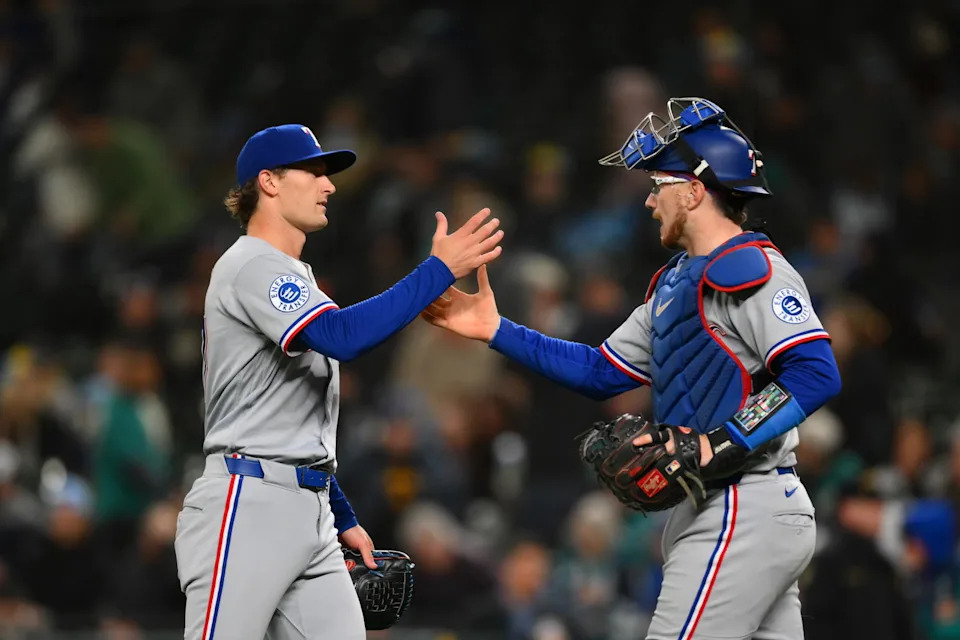 Texas Rangers pitcher Josh Latz (left) and catcher Danny Jansen celebrate after a 5-0 win against the Seattle Mariners on Friday at T-Mobile Park in Seattle. | Steven Bisig/Imagn Images.