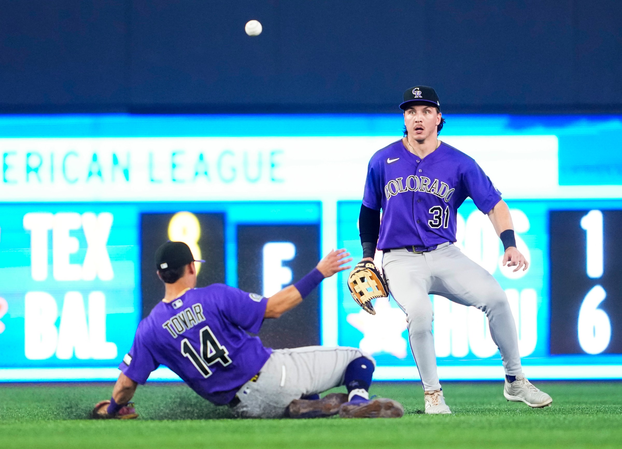 TORONTO, CANADA - MARCH 31: A ball drops between Jake McCarthy #31 and Ezequiel Tovar #14 of the Colorado Rockies against the Toronto Blue Jays during the eighth inning in their MLB game at the Rogers Centre on March 31, 2026 in Toronto, Ontario, Canada. (Photo by Mark Blinch/Getty Images)