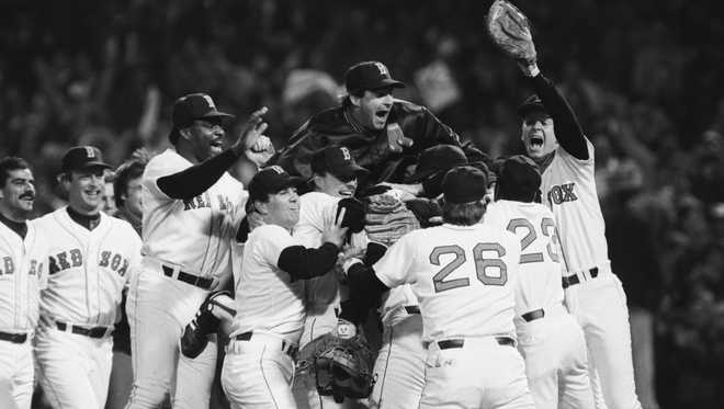 Players on the Boston Red Sox celebrate their American League championship victory, including Don Baylor (3rd from left), Bruce Hurst (top), Dave Stapleton (right), and playoff MVP Marty Barrett (left, in front of Baylor). October 15, 1986.