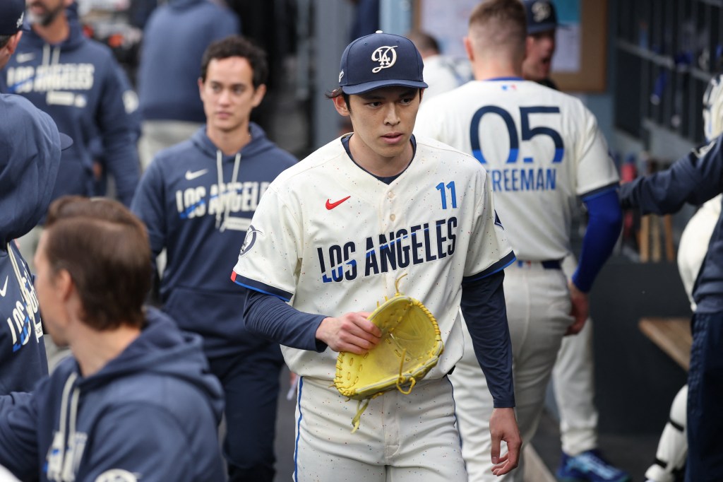 Los Angeles Dodgers pitcher Roki Sasaki (11) walks in the dugout.
