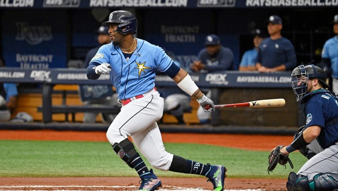 Seattle Mariners catcher Cal Raleigh, right, watches as Tampa Bay Rays' Yandy Diaz hits a lead off single off Seattle starter Bryce Miller during the first inning of a baseball game Sunday, Sept. 10, 2023, in St. Petersburg, Fla.