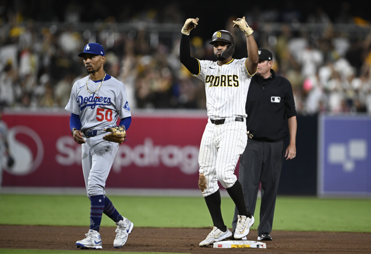 Aug 23, 2025; San Diego, California, USA; San Diego Padres shortstop Xander Bogaerts (2) celebrates after he hit an RBI double as Los Angeles Dodgers shortstop Mookie Betts (50) looks on during the eighth inning at Petco Park. Mandatory Credit: Denis Poroy-Imagn Images