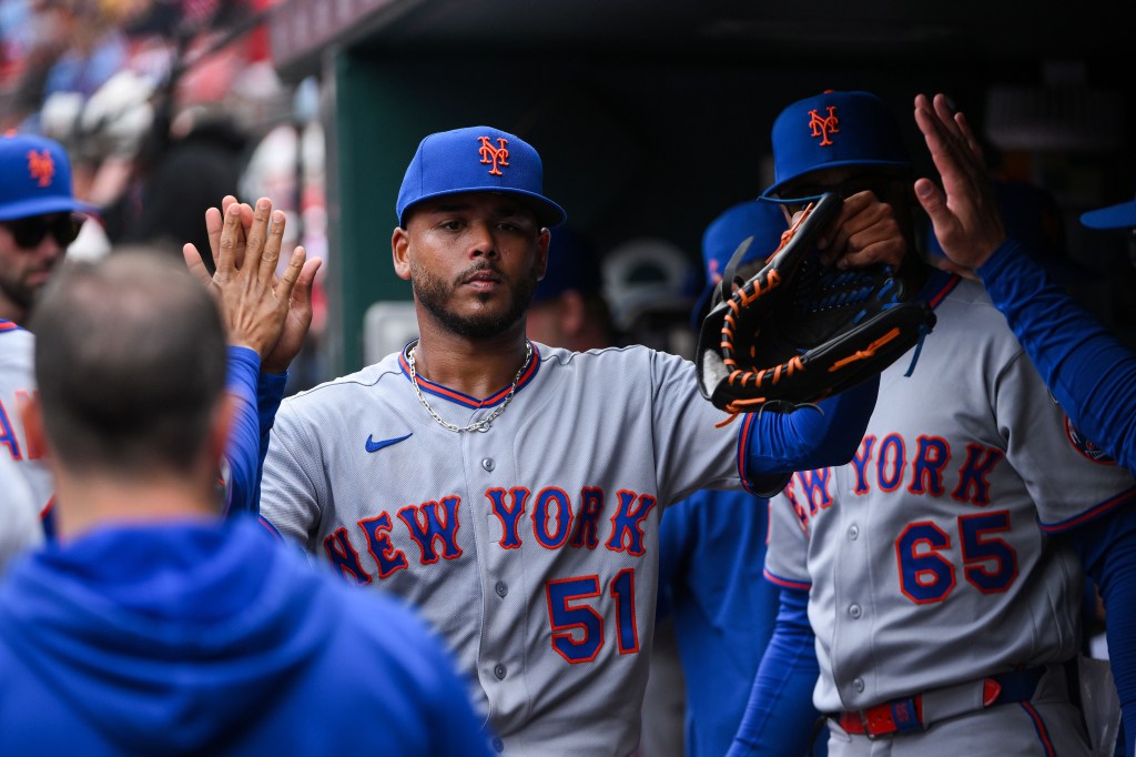 New York Mets starting pitcher Freddy Peralta (51) is congratulated by teammates after he was removed from the game during the sixth inning at Busch Stadium.
