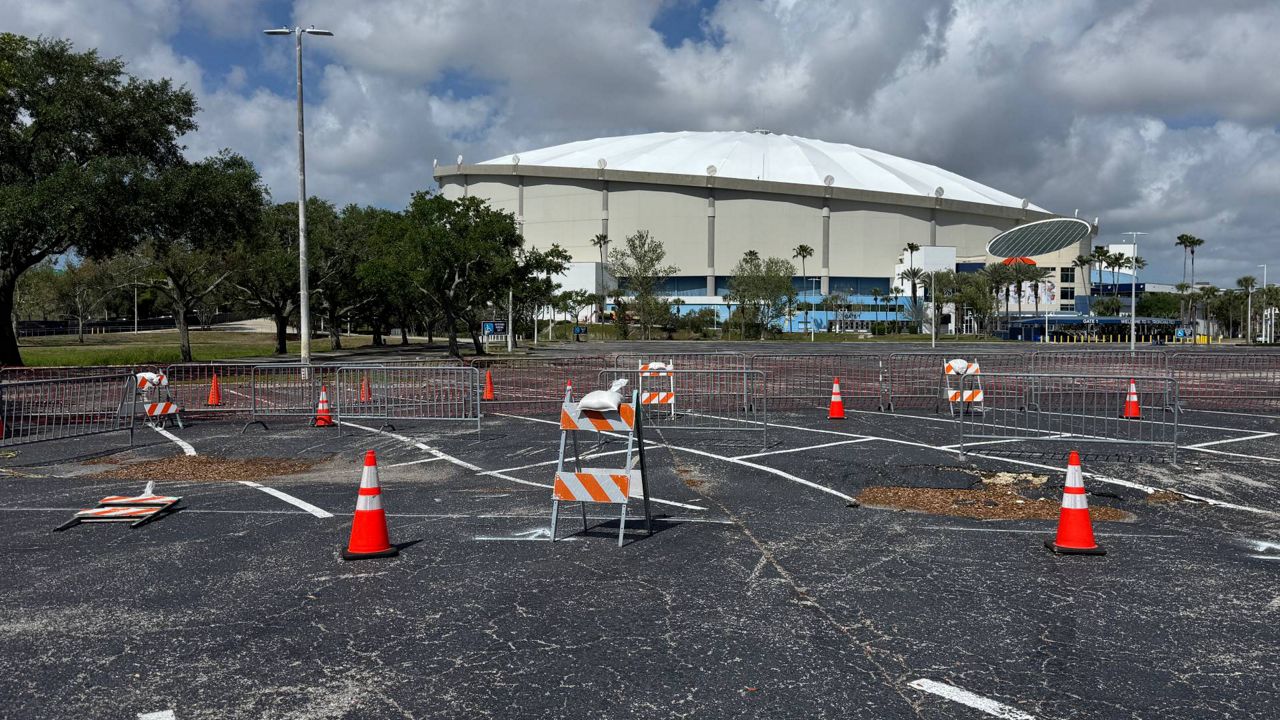 A small depression formed in Tropicana Field's parking lot. City officials said a water pipe broke and washed the dirt away. (Spectrum News/Andy Cole)