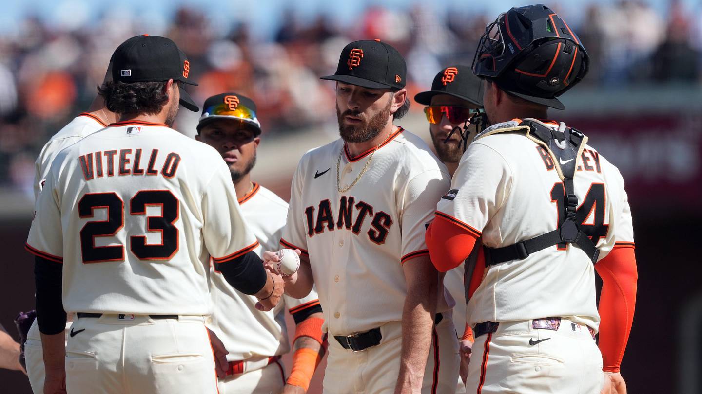 Mar 27, 2026; San Francisco, California, USA; San Francisco Giants pitcher Ryan Walker (center) hands the game ball to manager Tony Vitello (23) during the eighth inning against the New York Yankees at Oracle Park. Mandatory Credit: Darren Yamashita-Imagn Images