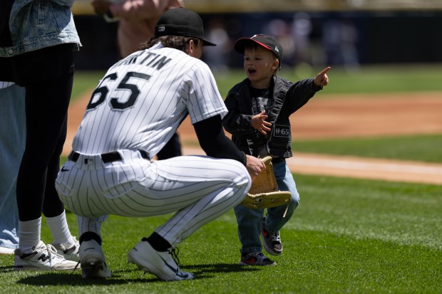 White Sox starting pitcher Davis Martin kneels to speak to his son Doak before a game against the Mariners on Sunday, May 10, 2026, at Rate Field. (Josh Boland/Chicago Tribune)