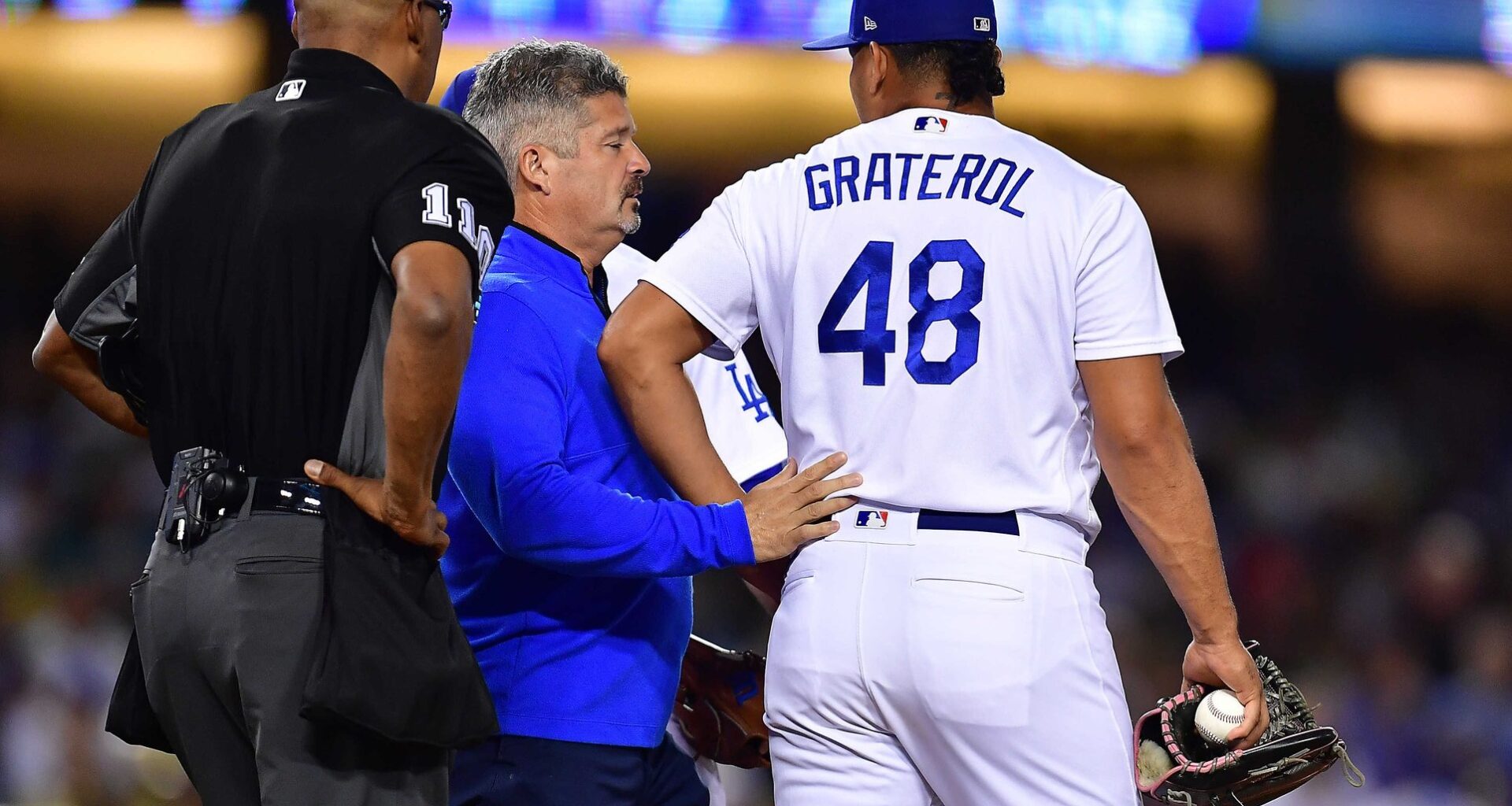 Jul 7, 2022; Los Angeles, California, USA; Los Angeles Dodgers trainer Nate Lucero speaks with relief pitcher Brusdar Graterol (48) during the eighth inning at Dodger Stadium. Mandatory Credit: Gary A. Vasquez-USA TODAY Sports