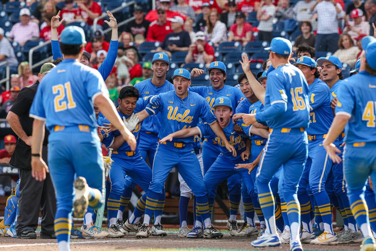 UCLA players celebrate at home plate as Jack O'Connor rounds the bases during the Big Ten tournament.