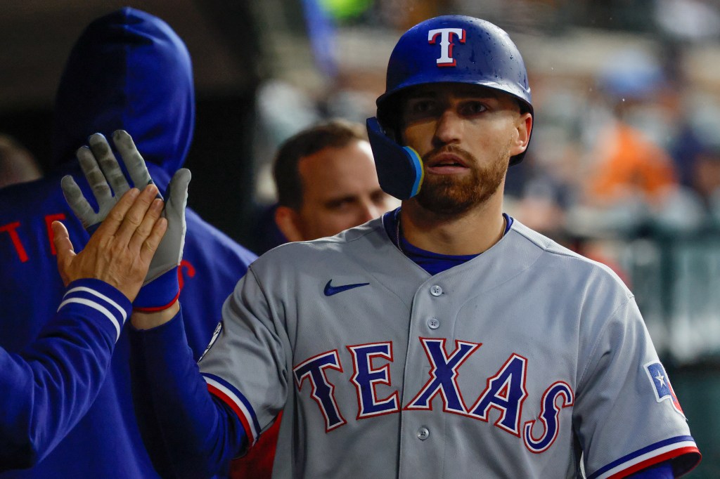 Texas Rangers right fielder Brandon Nimmo (24) receives congratulations from teammates after scoring 3i against the Detroit Tigers at Comerica Park. 