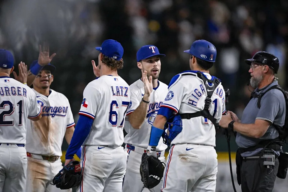Texas Rangers first baseman Jake Burger (21) and pitcher Jacob Latz (67) and center fielder Evan Carter (32) and catcher Kyle Higashioka (11) celebrate the win over the New York Yankees at Globe Life Field.