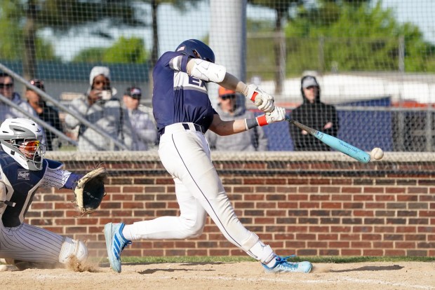 Oswego East's Dominic Battista (14) connects on a pitch for a single driving in a run against Oswego during a Southwest Prairie Conference game in Oswego on Monday, May 11, 2026. (Sean King / For The Beacon-News)