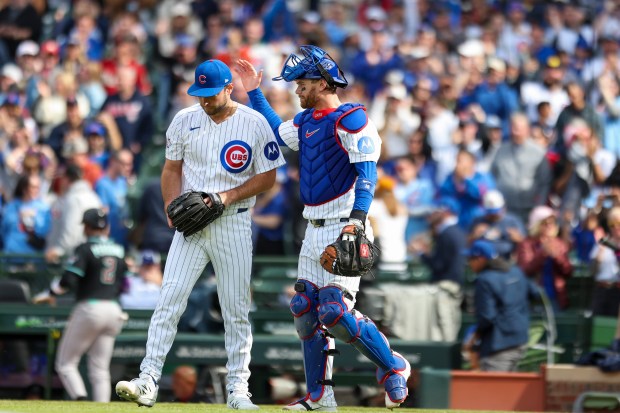 Chicago Cubs catcher Carson Kelly (15) pats pitcher Corbin Martin (38) on the back after they defeated the Arizona Diamondbacks 8-4 at Wrigley Field on May 3, 2026. (Eileen T. Meslar/Chicago Tribune)