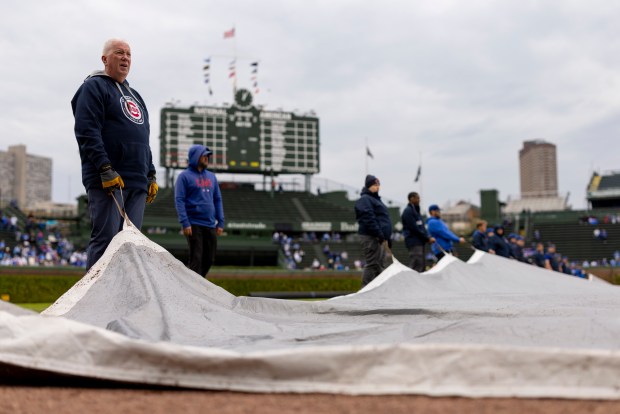 Grounds crew workers prepare to move the rain tarp off the infield before the Chicago Cubs game against the Arizona Diamondbacks at Wrigley Field on May 3, 2026. (Eileen T. Meslar/Chicago Tribune)