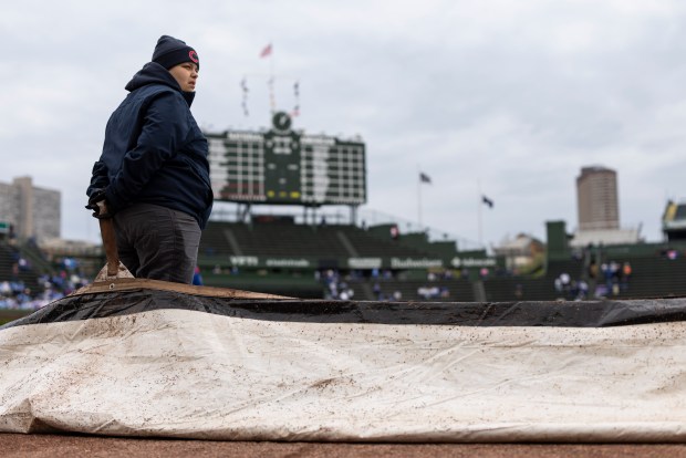 A grounds crew worker prepares to move the rain tarp off the infield before the Chicago Cubs game against the Arizona Diamondbacks at Wrigley Field on May 3, 2026. (Eileen T. Meslar/Chicago Tribune)