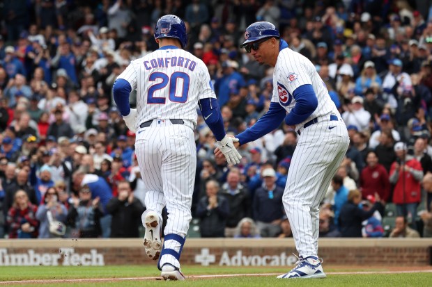 Cubs Michael Conforto (20) is congratulated by Cubs third base coach Quintin Berry (0) after hitting a home run against the Reds in the second inning at Wrigley Field on, May 7, 2026. (Terrence Antonio James/Chicago Tribune)