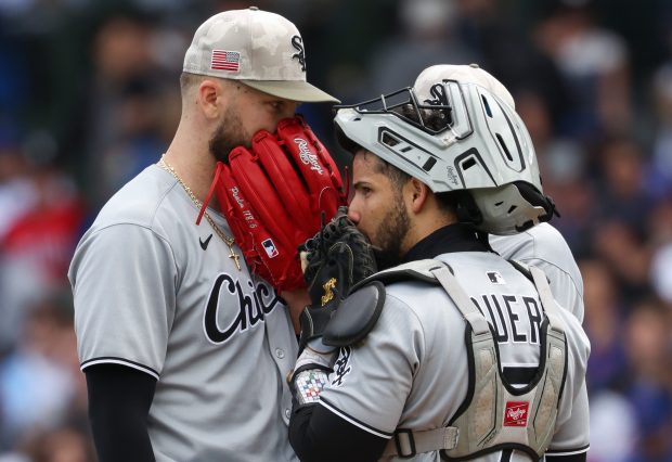 White Sox starter Sean Burke, left, and catcher Edgar Quero cover their mouths while having a meeting on the mound in the second inning against the Cubs on May 17, 2025, at Wrigley Field. (John J. Kim/Chicago Tribune)