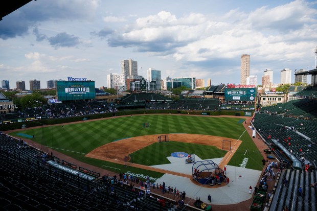 Cincinnati Reds players warm up before the first inning against the Chicago Cubs at Wrigley Field on May 4, 2026, in Chicago. (Armando L. Sanchez/Chicago Tribune)