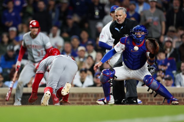 Reds outfielder Blake Dunn (59) scores off a RBI double from Reds left fielder Spencer Steer (7) past Cubs catcher Carson Kelly (15) during the eighth inning against the Cubs at Wrigley Field May 4, 2026, in Chicago. (Armando L. Sanchez/Chicago Tribune)