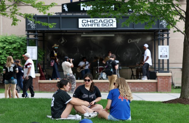 Fans relax in the grass outside of Rate Field in Chicago before a game between the Chicago White Sox and the Chicago Cubs on May 16, 2026. (Chris Sweda/Chicago Tribune)