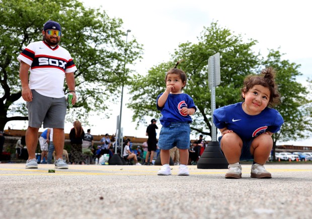 Oscar Nava (cq) and his children, Reign (cq) (center), 12 months, and Ocean (cq) (right), 2, relax while tailgating outside of Rate Field in Chicago before a game between the Chicago White Sox and the Chicago Cubs on May 16, 2026. (Chris Sweda/Chicago Tribune)