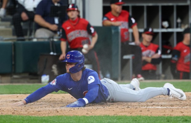 Cubs second baseman Nico Hoerner slides home on an RBI double from first baseman Michael Busch in the fifth inning against the White Sox at Rate Field on May 15, 2026, in Chicago. (John J. Kim/Chicago Tribune)