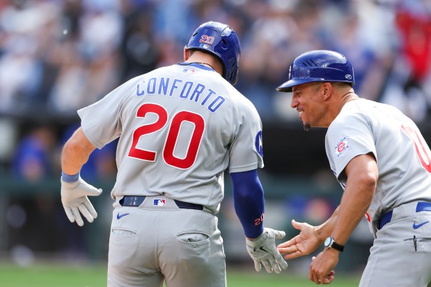 Chicago Cubs third base coach Quintin Berry (0) high-fives right fielder Michael Conforto (20) after he hit a three-run home run to tie the game during the 9th inning against the Chicago White Sox at Rate Field on May 17, 2026. (Eileen T. Meslar/Chicago Tribune)