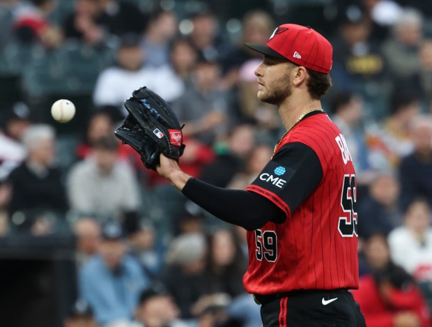 White Sox starting pitcher Sean Burke retrieves a ball after giving up a grand slam to Mariners right fielder Luke Raley in the third inning at Rate Field on May 8, 2026, in Chicago. (John J. Kim/Chicago Tribune)
