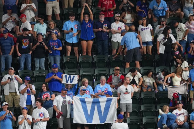 Cubs fans hold banners following the team's 7-1 win over the Rangers on Friday, May 8, 2026, in Arlington, Texas. (Julio Cortez/AP)