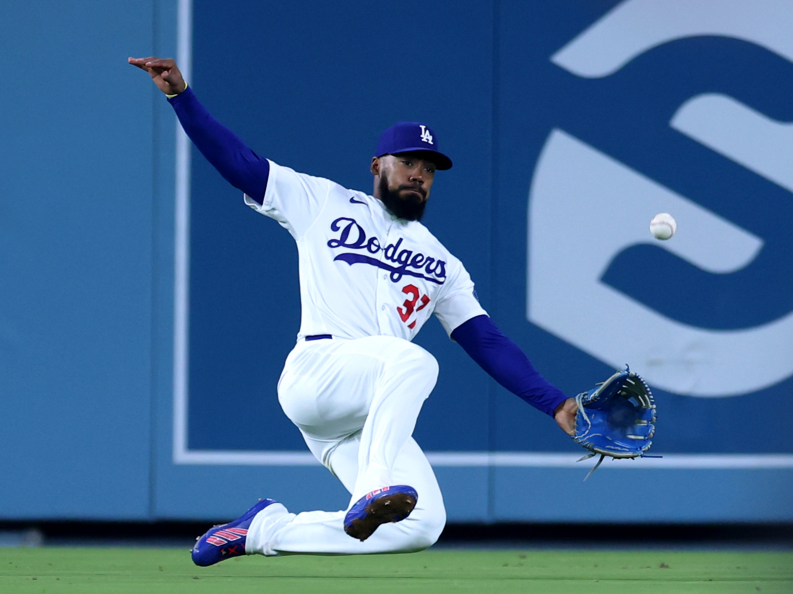 Dodgers left fielder Teoscar Hernandez slides as he tries to...