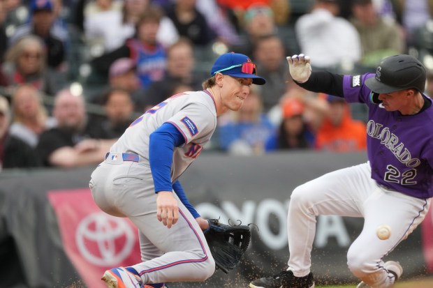 New York Mets third baseman Brett Baty (7) fields the throw as Colorado Rockies left fielder Mickey Moniak (22) slides into third base with a triple in the eighth inning of a baseball game Monday, May 4, 2026, in Denver. (AP Photo/David Zalubowski)