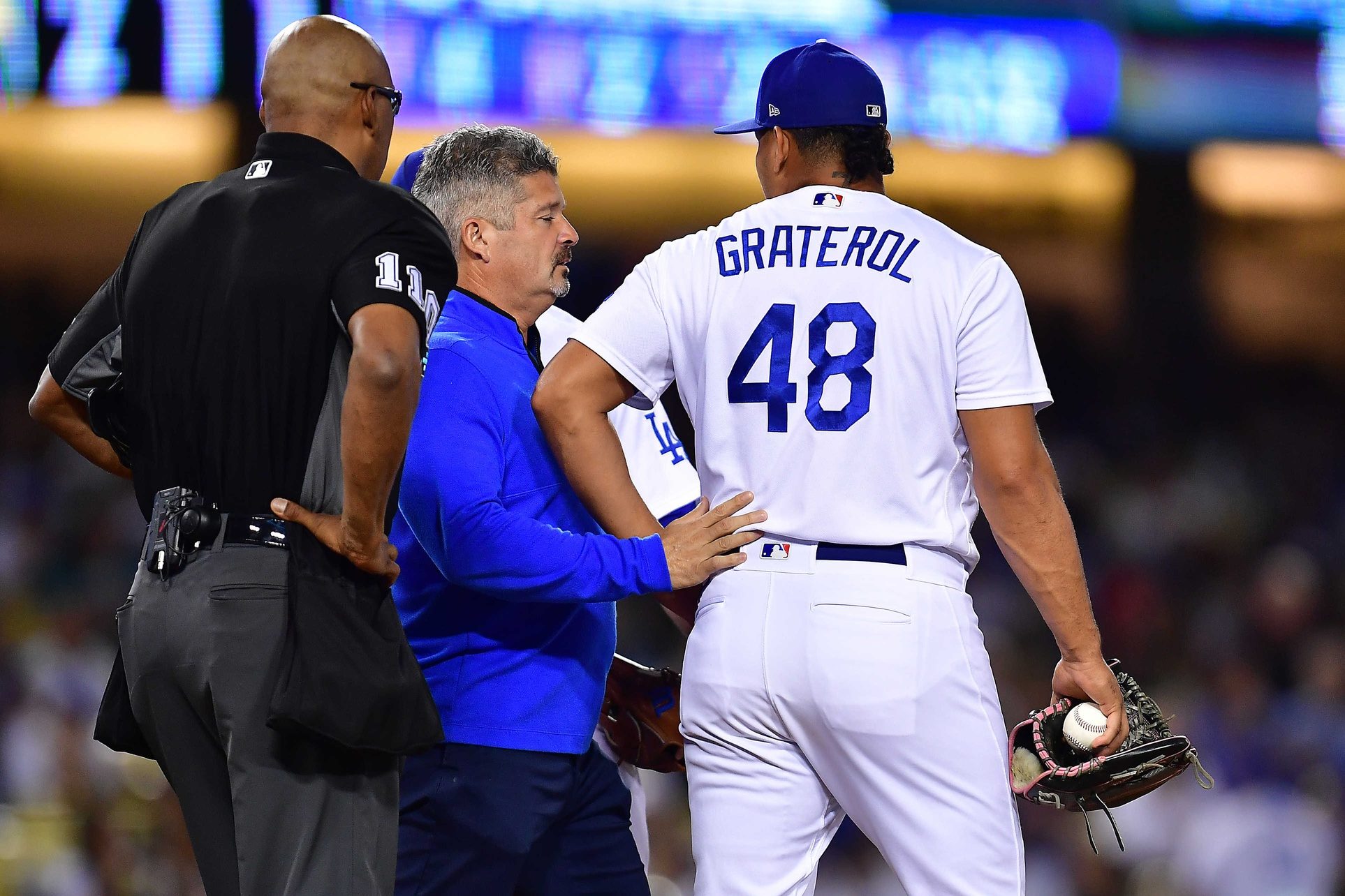 Jul 7, 2022; Los Angeles, California, USA; Los Angeles Dodgers trainer Nate Lucero speaks with relief pitcher Brusdar Graterol (48) during the eighth inning at Dodger Stadium. Mandatory Credit: Gary A. Vasquez-USA TODAY Sports
