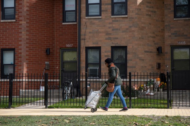 A woman walks along the newly installed yellow bricks on Nov. 4, 2019, outside the West Side home where L. Frank Baum lived in the late 1800s while writing "The Wonderful Wizard of Oz." (Raquel Zaldivar/Chicago Tribune)