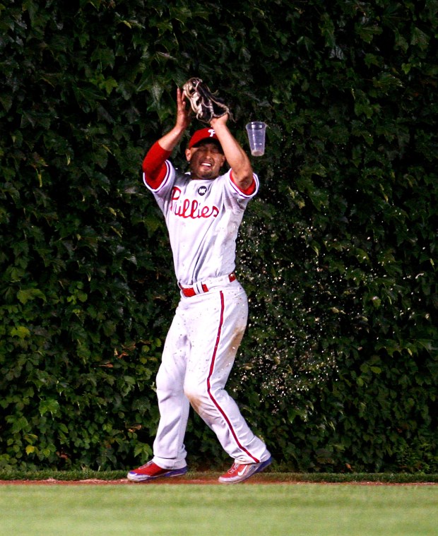 CHICAGO - AUGUST 12: Shane Victorino #8 of the Philadelphia Phillies is hit by a beer thrown by a fan in the bleachers as he makes a catch of a fly ball hit by Jake Fox of the Chicago Cubs in the 5th inning on August 12, 2009 at Wrigley Field in Chicago, Illinois. (Photo by Jonathan Daniel/Getty Images)