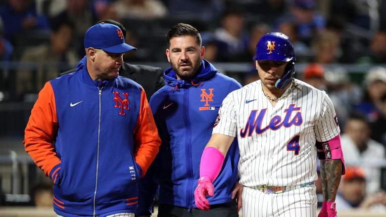 New York Mets catcher Francisco Alvarez leaves the game against the Detroit Tigers at Citi Field, accompanied by manager Carlos Mendoza.