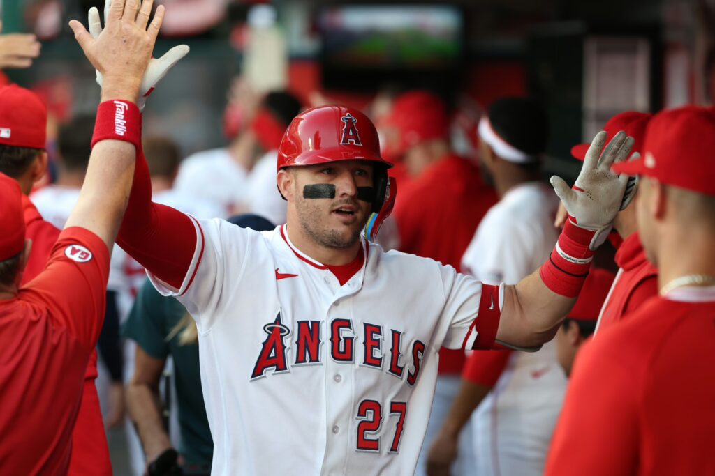 Los Angeles Angels center fielder Mike Trout (27) is greeted in the dugout after hitting a two-run home run during the first inning against the Texas Rangers at Angel Stadium.