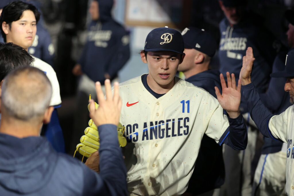 Los Angeles Dodgers pitcher Roki Sasaki (11) is greeted in the dugout after leaving the game during the sixth inning against the Philadelphia Phillies at Dodger Stadium.