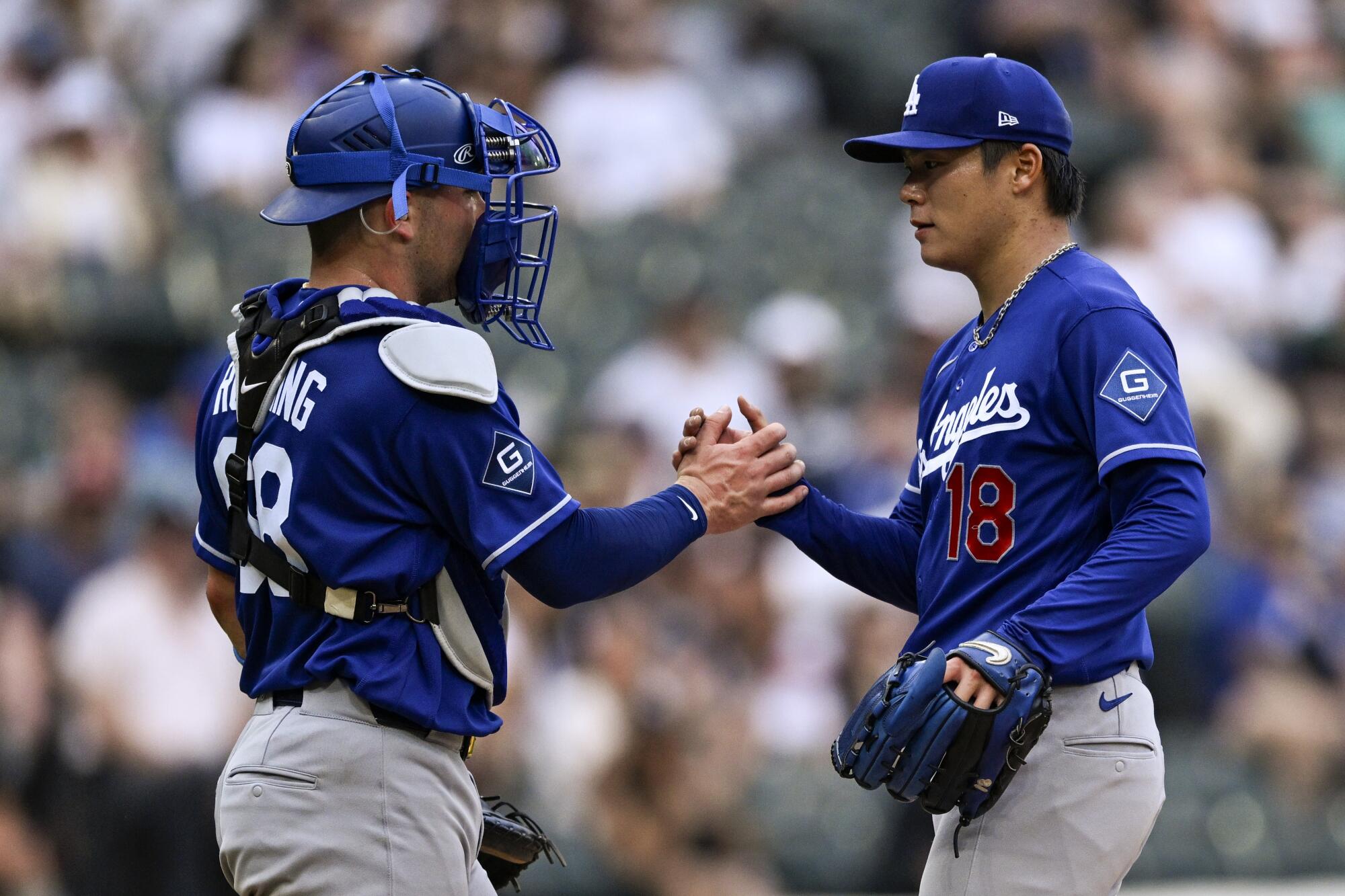 Dodgers catcher Dalton Rushing slaps hands with Dodgers pitcher Yoshinobu Yamamoto.