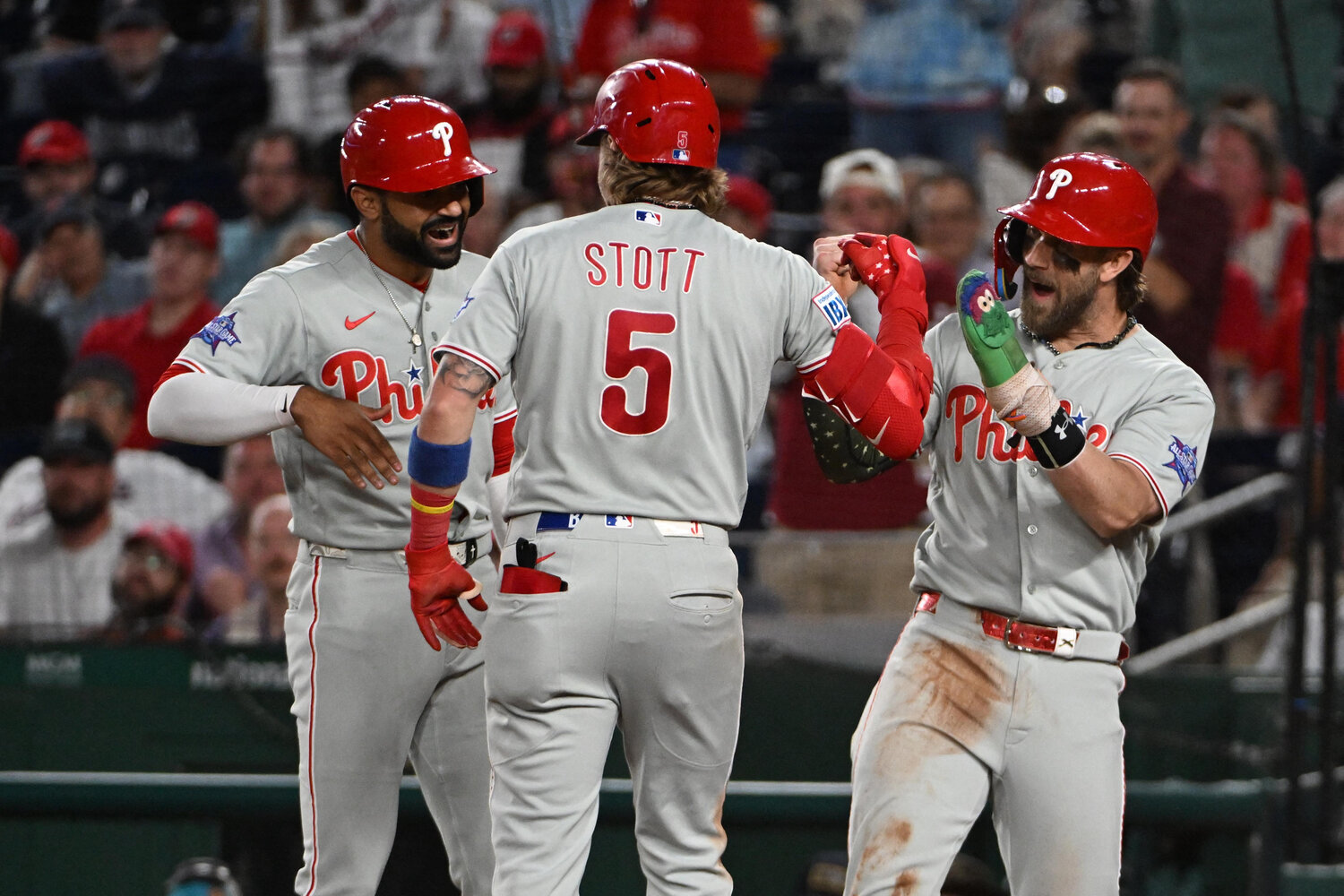 Philadelphia Phillies second baseman Bryson Stott (5) celebrates with right fielder Derek Hill (left) and first baseman Bryce Harper (3) after hitting a three run home run against the Washington Nationals during the ninth inning at Nationals Park.