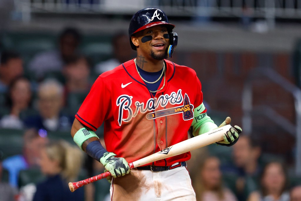 Ronald Acuna Jr. in a red and brown Atlanta Braves uniform holding a bat.