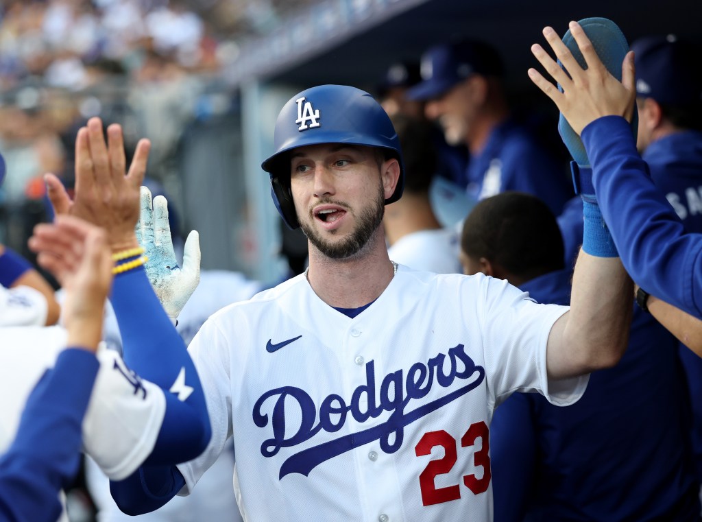 Max Muncy of the Los Angeles Dodgers high-fiving teammates in the dugout.